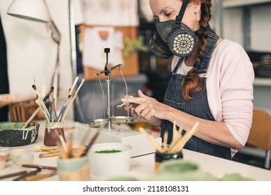 Mature woman working inside ceramic pottery studio with powder and scale while wearing a mask - Hand made artwork handcraft - Powered by Shutterstock