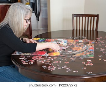 Mature Woman Working On Puzzle At Home