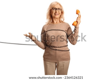 Mature woman wrapped in a cable holding a rotary phone isolated on white background