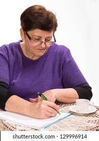 Mature woman writing documents with cup of coffee on a white background
