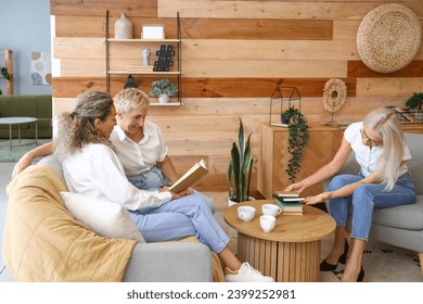 Mature women taking part in book club at home - Powered by Shutterstock