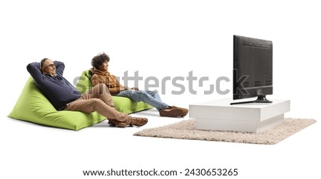 Mature and young man sitting on a green beanbag chair and relaxing in front of tv isolated on white background