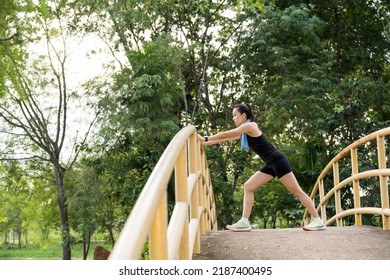 Matured Asian woman stretching to workout in the natural city park. Fitness stock photo