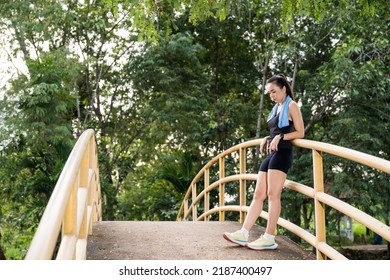 Matured Asian woman stretching to workout in the natural city park. Fitness stock photo