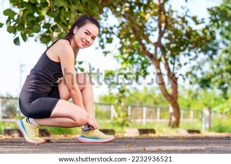 A matured Asian woman wearing black sportswear jogging exercise in the city park