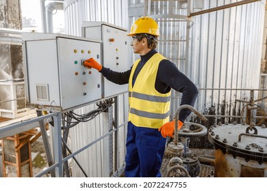 Matured man engineer wearing safety helmet and work vest while pressing button on electric control box at plant - Powered by Shutterstock