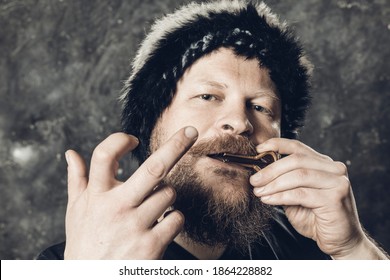 Matured Man In Fur Hat Playing Jews Harp