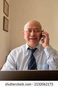 A Matured Senior Office Worker With A Big Smile After Hearing Good News Of A Big Business Deal On The Phone.