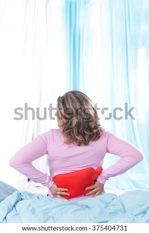 Matured woman with back pain in bed