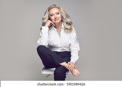 Maturity and style of adult woman. Fashionable mature female portrait on a grey isolated.