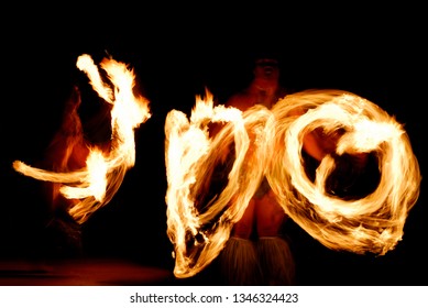 Maui, Hawaii, United States - April 26, 2006: Two Fire Dancers Spinning Lit Batons At Night After A Luau