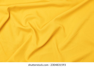 Mauled yellow-colored fabric texture background. This fabric is made of polyester and spandex.