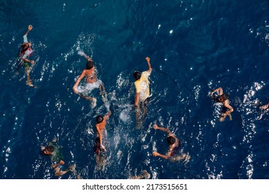 Maumere-Flores, Indonesia, June 23, 2022. Boys are having fun swimming in the blue sea of Flores. School holidays and summer are opportunities to play outdoors                        