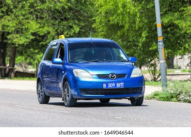 Maun, Botswana - February 9, 2020: Blue Taxi Car Mazda Demio In The Town Street.