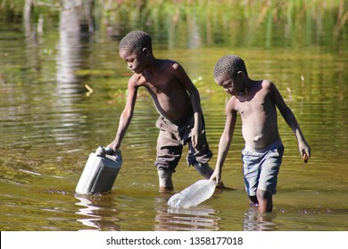Maun,Botswana,Africa.June 2012.Two African boys collect water from the river.Millions of Africans lack access to clean and safe water for drinking.