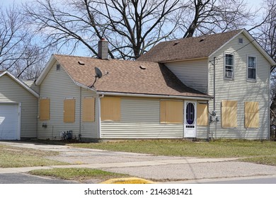 Mauston, Wisconsin USA - April 12th, 2022: Tan Boarded Up Drug House Seized By The State.