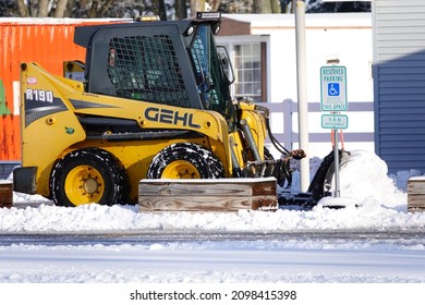 Mauston, Wisconsin USA - December 20th, 2021: GEHL Track And Skid Loader Being Used To Plow Snow. 