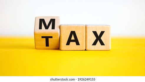 Max tax symbol. Turned wooden cubes with words 'max tax'. Beautiful yellow table, white background, copy space. Business and max tax concept.