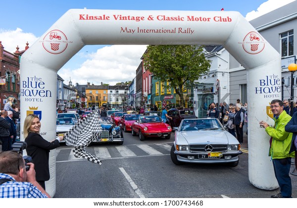 The May 11th 2019 Kinsale, Ireland, vintage and\
classic motor rally. Waiting before the race begins. Officials at\
the starting line ready to signal the race start with the car race\
flag.