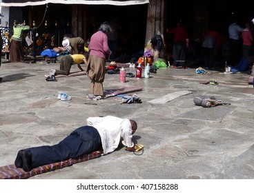 May 12, 2014  Jokhang Temple, Barkhor Square, Lhasa, Tibet. Tibetan pilgrims and worshipers prostrating themselves in prayers at the Buddhist temple considered the holiest site in Tibetan Buddhism.