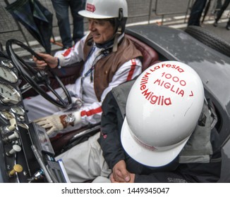 May 18, 2019: A Driver And Navigator In The Mille Miglia, Outfitted In Vintage Plastic Helmets, Roll Into Brescia, Italy To Complete The 1,000 Mile Classic Car Race.