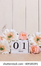 May 1st. Happy May Day White Block Wood Calendar Decorated With Spring Flowers On Wood Table.