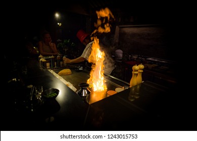 May, 2018 - Ari Atoll, Maldives: Happy Teppanyaki Chef Cooking Vegetables At Teppan In A Japanese Steakhouse On Mishi Sushi. Gourmet Food In Luxury Restaurant. 