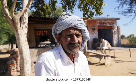 May 2020- Mahroli, Jaipur, India. Rude Or Unhappy Expression Of An Old Man, Sitting In A Rural Landscape. Old Age Concept.