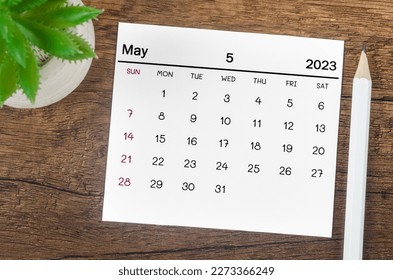 May 2023 Monthly calendar for 2023 year with pen on wooden background.