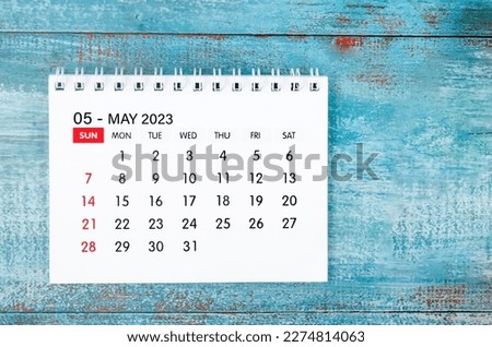 May 2023 Monthly desk calendar for 2023 year on old blue wooden background.