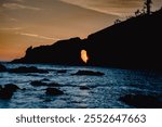 MAY 2024, OLYMPIC NATIONAL PARK, WASHINGTON STATE -  sunset through arched rock at Lapush, Ruby Beach, Washington