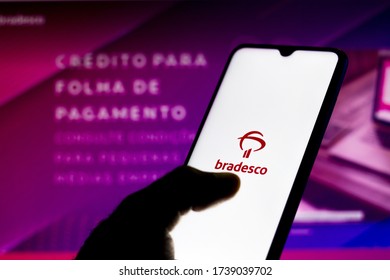 May 22, 2020, Brazil. In this photo illustration the Bradesco logo seen displayed on a smartphone with a computer model of the bank's official website in the background.