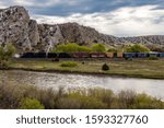 MAY 23 2019, USA - THREE FORKS, MT - Missouri River Breaks National Monument, the source of the Missouri River, freight train runs along river