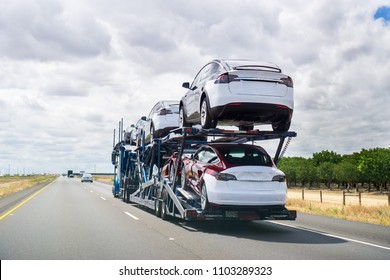 May 25, 2018 Bakersfield / CA / USA - Car transporter carries Tesla Model 3 new vehicles along the highway, back view of the trailer