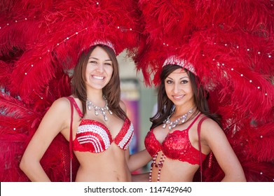 May 27, 2013. Las Vegas, Nevada, USA. Beautiful female dancers or performers wearing a costume and a head dress with red feathers, red and white sequins. Smiling and looking at the camera