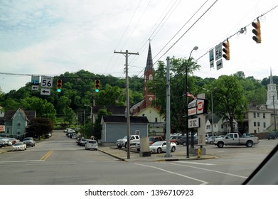 May 28th, 2016, Aurora, IN, Small Town Street Corner Intersection With Church Steeple And Hills In The Background 