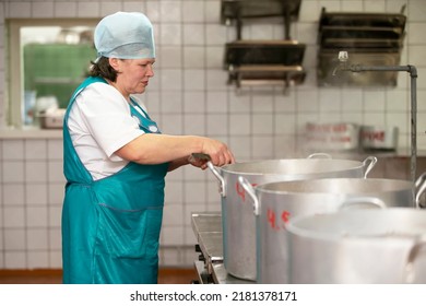 May 31, 2021 Belarus, Gomel, Industrial Kitchen. The Chef Prepares Food In Large Pots In An Industrial Kitchen. Public Dining Room.