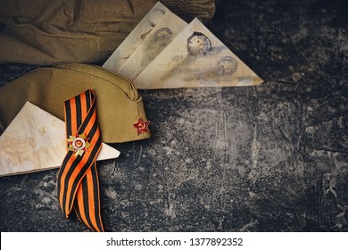 may 9 victory day holiday background. ribbon of St.George, soldier's war letter, military cap - traditional symbol of Victory Day 1945. greeting card design. top view. copy space