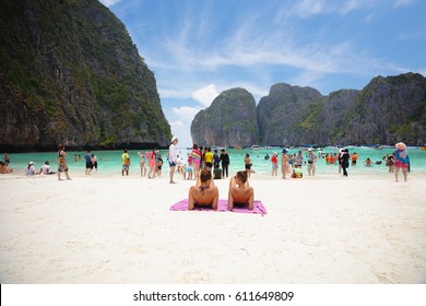MAYA BAY, THAILAND - MARCH, 2017: Crowds of sunbathing visitors enjoy a day trip boat ride to Maya Bay, one of the iconic beaches of Southern Thailand.