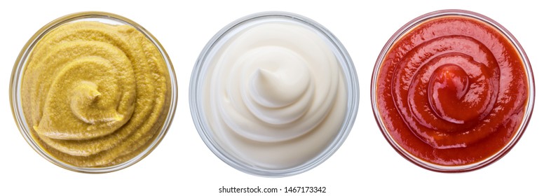 Mayonnaise, mustard and tomato sauces ketchup in white bowls. File contains clipping path.