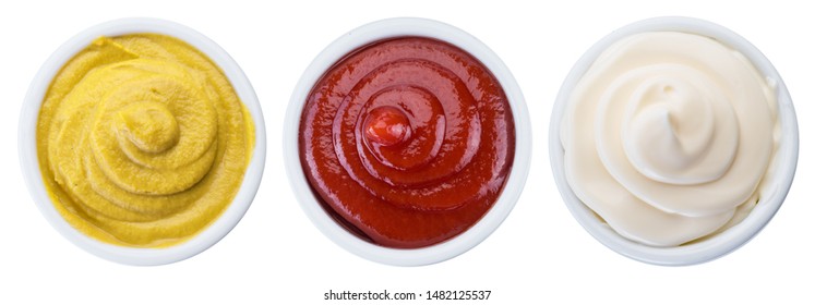 Mayonnaise, mustard and tomato sauces in white bowls. File contains clipping path.