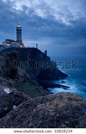 Similar – Leuchtturm an felsiger Küste am Meer