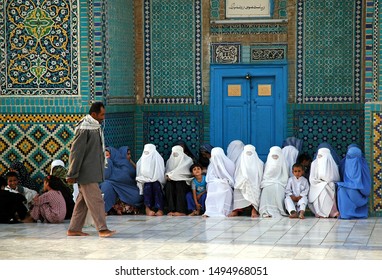 Mazar-i-Sharif, Balkh Province / Afghanistan - Aug 31 2005: Afghan Women Wearing Blue And White Burqas (burkas) Wait Outside The Blue Mosque In Mazar I Sharif As A Man Walks Past. Northern Afghanistan