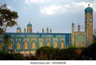 Mazar-i-Sharif, Balkh Province In Afghanistan. The Garden Of The Blue Mosque In Mazar I Sharif. Some People Enjoy The Sunshine. Colorful Mosaics And Tiles Adorn The Mosque Walls. Northern Afghanistan.