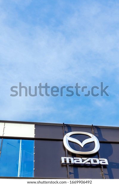 Mazda\
brand logo on bright blue sky background located on its dealer\
office building in Lyon, France - February 23,\
2020
