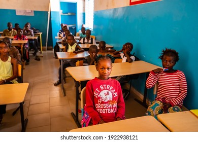 MBOUR, SENEGAL - DECEMBER Circa, 2020. Unidentified serious and sad african children sitting at desks in a classroom in a primary school. New class with new desks, roof, paintings. NGO help.