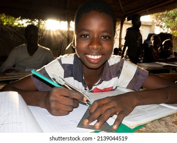 MBOUR, SENEGAL - DECEMBER Circa, 2021. Unidentified Young Child Writing Letter To Godfather Or Godmother Because European NGO Help Him To Pay School And Food For Family. Close-up On Hands