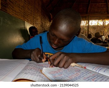 MBOUR, SENEGAL - DECEMBER Circa, 2021. Unidentified Young Child Writing Letter To Godfather Or Godmother Because European NGO Help Him To Pay School And Food For Family. Close-up On Hands