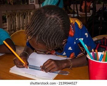 MBOUR, SENEGAL - DECEMBER Circa, 2021. Unidentified Young Child Writing Letter To Godfather Or Godmother Because European NGO Help Him To Pay School And Food For Family. Close-up On Hands