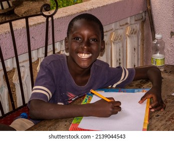 MBOUR, SENEGAL - DECEMBER Circa, 2021. Unidentified Young Child Writing Letter To Godfather Or Godmother Because European NGO Help Him To Pay School And Food For Family. Close-up On Hands